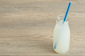 Litchi juice in a glass bottle with a blue straw
