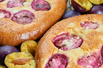 Home made plum buns on a wooden table