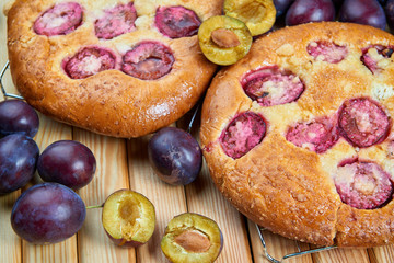 Home made plum buns on a wooden table
