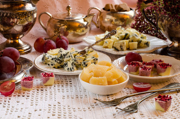 A beautiful table setting with cheeses and desserts.