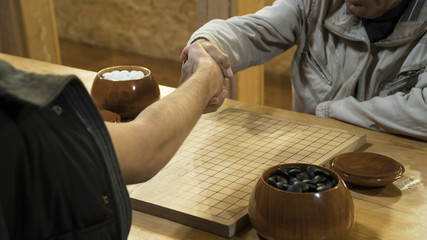 Hand shake before play Chinese board game Go or Weiqi 