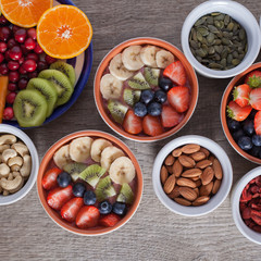Smoothie  with fruits and berries on the grey wooden table, with variety of fruits and nuts around, top view, square