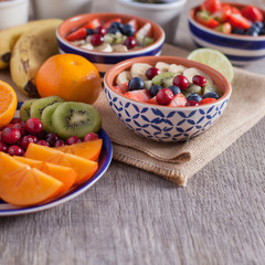 Smoothie  with fruits and berries on the grey wooden table, with variety of fruits around, selective focus
