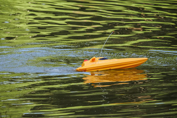 Remote controlled yellow speedboat racing after reversal