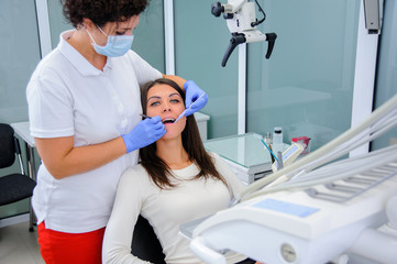 Woman dentist working at her patients teeth