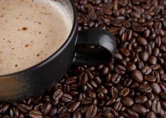 Large cup with hot cappuchino with coffee beans