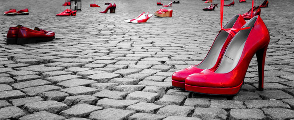 red shoes to stop violence against women on a city square - obrazy, fototapety, plakaty
