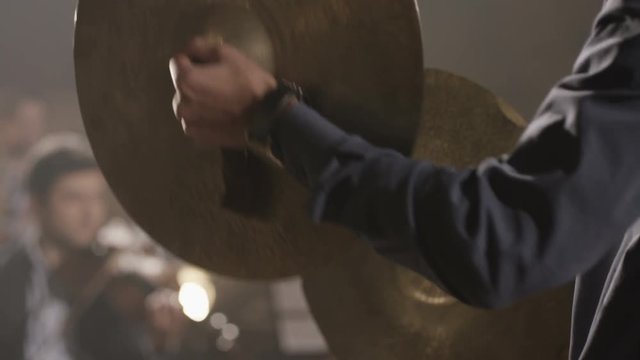 Man playing on ride cymbal on the symphony hall. Shot on RED EPIC Cinema Camera in slow motion.