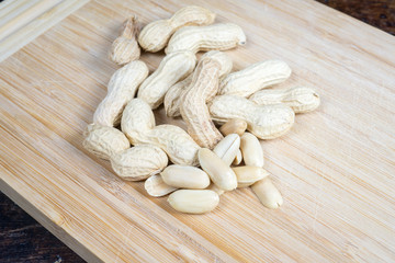 dried fruit, nuts, hazelnuts and almonds on cutting board and antique table
