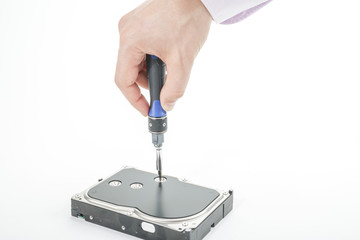 Hand repairman unscrews the 3.5 inch hard drive cover with a screwdriver. Isolated on white background.