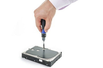 Hand repairman unscrews the 3.5 inch hard drive cover with a screwdriver. Isolated on white background.