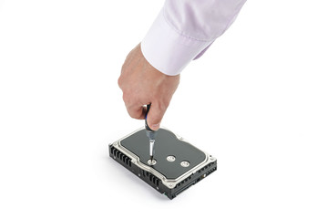 Hand repairman unscrews the 3.5 inch hard drive cover with a screwdriver. Isolated on white background.