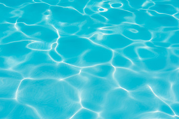 Fototapeta na wymiar Beautiful blue water surface in swimming pool with sun reflection