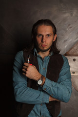stylish man with long hair smoking electronic cigarette