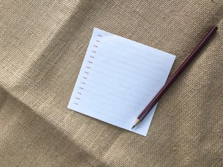 Fototapeta premium Note paper and pencil on sackcloth