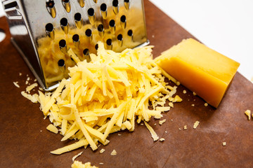 Cheese rubbed on a grater on a dark Board.