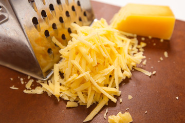 Cheese rubbed on a grater on a dark Board.
