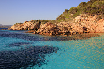 In Sardegna mare e cielo, acqua e rocce, acqua limpida, sole sull'isola.