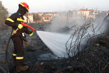 Firefighter extinguish fire in a field by water flooding