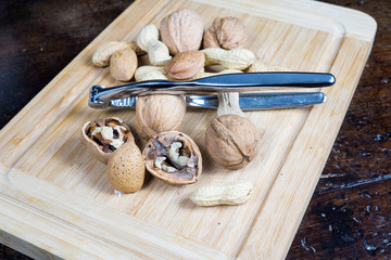 dried fruit, nuts, hazelnuts and almonds on cutting board and antique table
