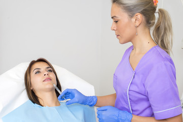 Fototapeta premium Young Woman Geting an Injection in her Lips in Beauty salon.