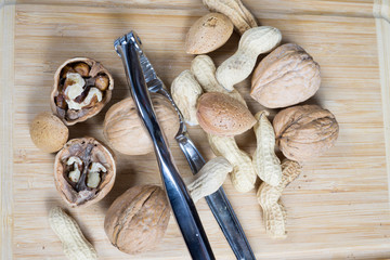 dried fruit, nuts, hazelnuts and almonds on cutting board and antique table