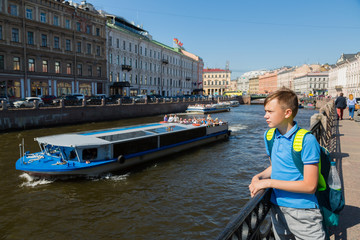 Fototapeta na wymiar Guy is on the waterfront canal in St. Petersburg
