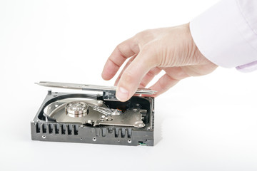 Hand repairman opens the top cover of the 3.5 inch HDD. Isolated on white background.