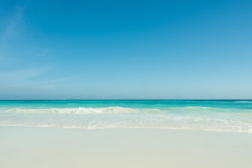 Fototapeta na wymiar Beautiful gentle wave at the tropical beach with blue sky