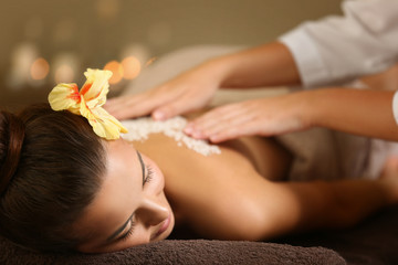 Young woman receiving salt massage in spa salon