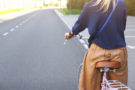 Young woman riding bicycle along road, close up view