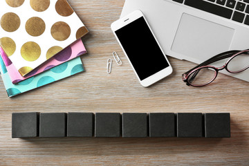 Fototapeta premium Laptop, copybook and wooden cubes on color background
