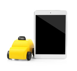 Yellow toy taxi cab and tablet isolated on white