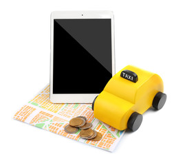 Yellow toy taxi, tablet, map and coins isolated on white