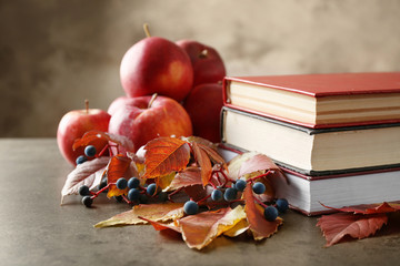 Beautiful autumn composition with pile of books on grey background