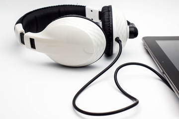 Headphones with tablet on white background.