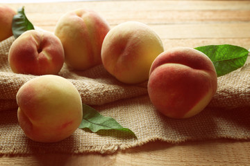 Fresh juicy peaches on bagging and wooden background
