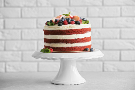 Delicious cake with fruit and berries decoration on gray table
