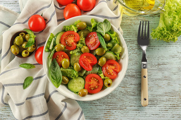 Tasty vegetable salad with fork on kitchen table
