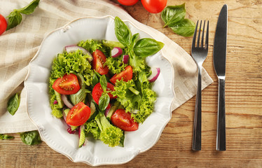 Tasty vegetable salad with cutlery on kitchen table