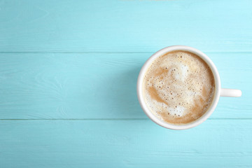 Cup of fresh coffee on light blue background