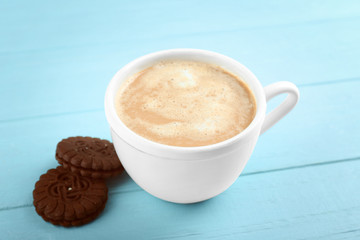 Cup of fresh coffee on light blue background