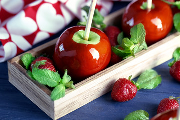 Candy apples with strawberry on wooden table closeup