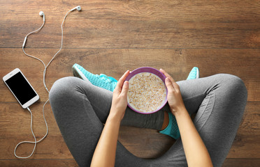 Athletic girl with healthy food on floor