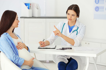 Young pregnant woman visiting doctor