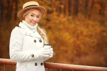 Beautiful girl with coffee in autumn park