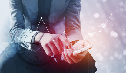 Double exposure of businessman holding smart phone with a row of stack money coins and analog clock...