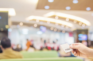 Man is holding queue card while waiting in the modern reception area