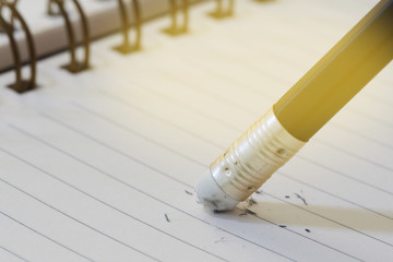 pencil eraser removing a written mistake on a note book, school