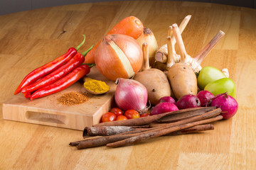 Wooden table with colorful spices, herbs and vegetables. Wooden